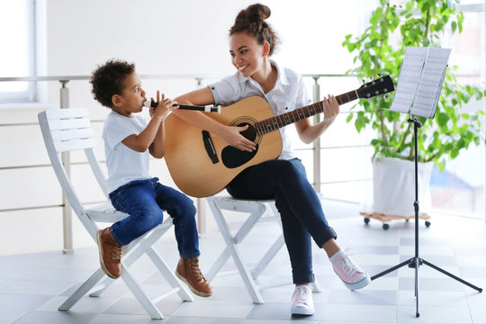 Young girl and little boy playing on music instruments