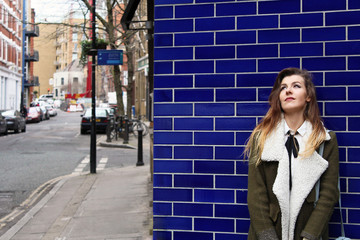 Smart young woman against blue wall