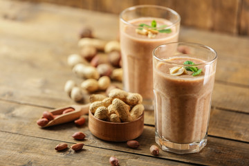 Fresh banana cocktail with peanuts on wooden table