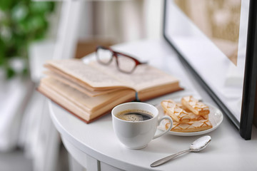 White cup of the coffee on the table  in a light room..
