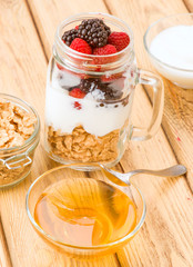 transparent jar with berries and yogurt cereals