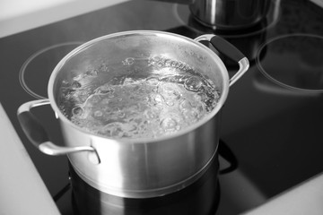 Boiling spaghetti in pan on electric stove in the kitchen - obrazy, fototapety, plakaty