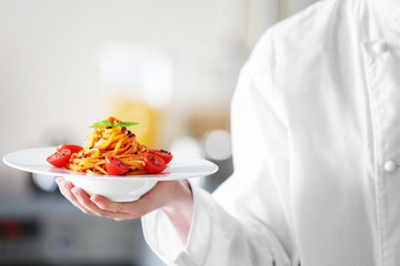 Chef hand holding delicious cold pasta salad in bowl on the table closeup - Powered by Adobe