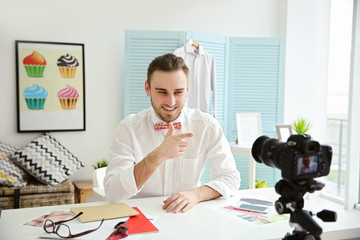 Young male blogger recording video at home