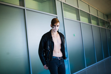 Portrait of Man with tattooed Face in leather Jacket on stadium