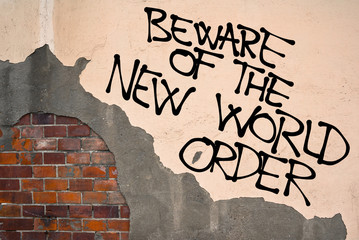 Handwritten graffiti Beware Of The New World Order sprayed on the wall, anarchist aesthetics....