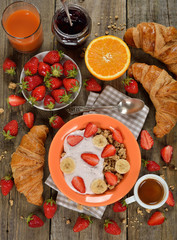 Muesli with yogurt, croissant and fresh strawberries