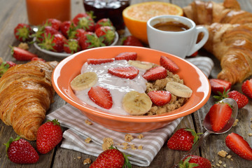 Muesli with yogurt, croissant and fresh strawberries