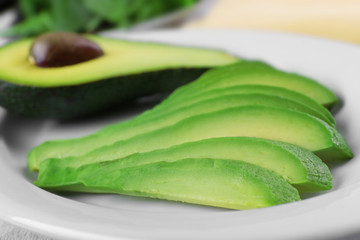 Slices of fresh avocado on plate closeup