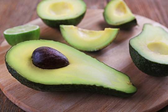 Fresh avocado on wooden cutting board closeup