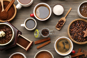 Assorted fresh coffee with spices on wooden table, top view