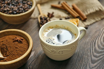 Coffee with beans and spices on wooden table closeup