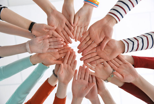 Group of people hands together, looking up view