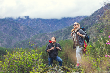 Young couple in the mountains with backpacks
