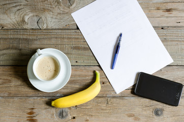 Banana and coffee on the old wooden table