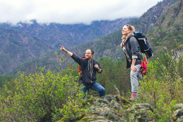 Young couple in the mountains with backpacks