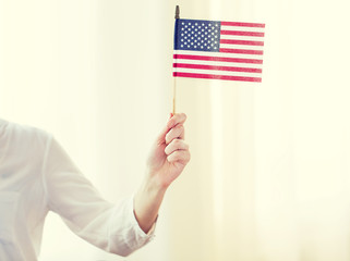 close up of woman holding american flag in hand