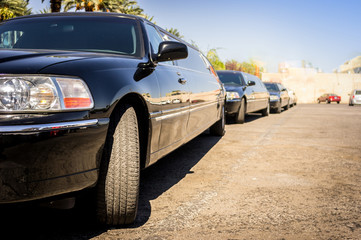 Three black limousines in a row.