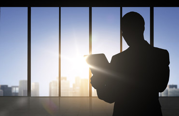 silhouette of businessman with tablet pc at office