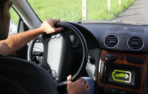 young man driving with battery information on digital dashboard