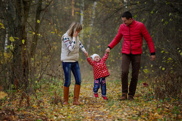 father and mother holding crying little daughter