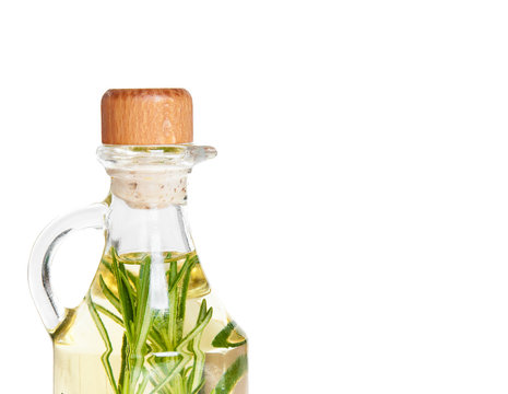 Oil in a bottle and fresh organic rosemary isolated on white