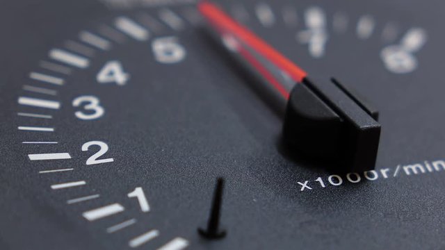 Close up shot of real tachometer with the pointer going to maximum value. Not animation. Shallow DOF