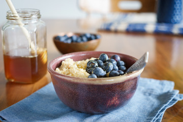 Oats porridge served with blueberries and honey. Selective focus.