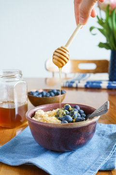 Oats porridge served with blueberries and honey. Selective focus.