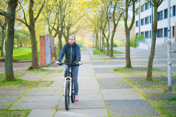 Young woman with bike in spring city