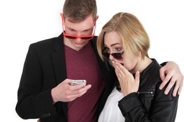 junges Paar schaut überrascht auf ein Handy