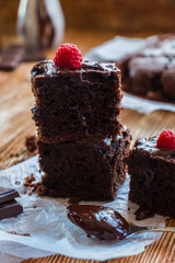 Homemade chocolate brownies with raspberry on the wooden background
