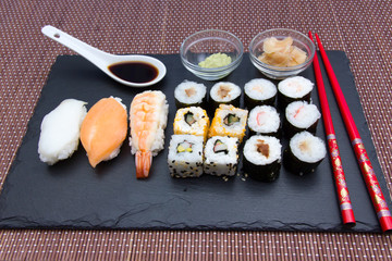 Sushi on flat slate on a bamboo mat