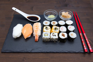 Sushi on flat slate on a wooden table