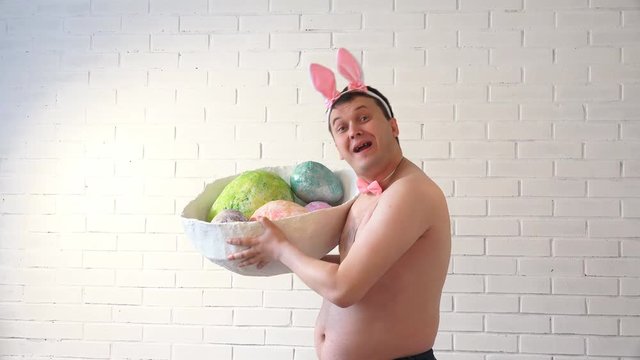 man with hare ears for Easter holds in hands big easter egg