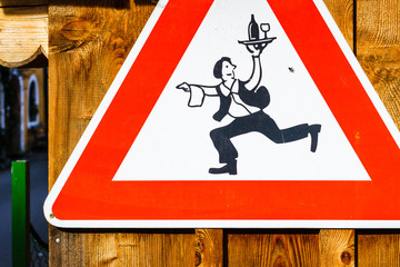 Road sign with waiter holding tray with drink