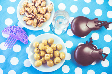 Close-up of green olives, mussels and costume jewelry