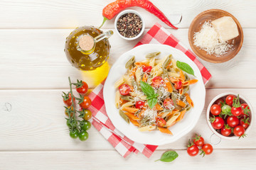 Colorful penne pasta with tomatoes and basil