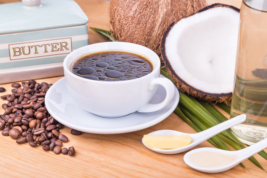 Closeup of bulletproof coffee with cold pressed extra virgin coconut oil and organic butter on wooden table, part of ketogenic diet