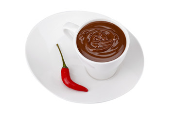 chilly pepper and cup of chocolate in a plate