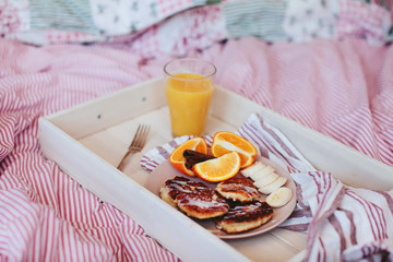breakfast in bed, pancakes with fruit and juice on a tray