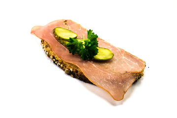 Schinkenbrot mit Gurke und Petersilie auf weißen Hintergrund