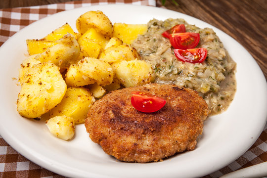 Delicious meal of minced meat cutlet, potatoes and fried cabbage