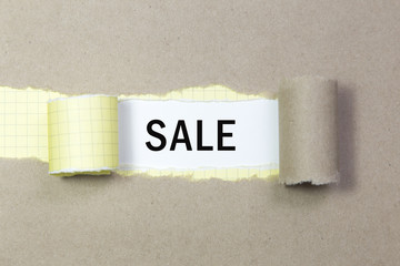 The text SALE appearing behind torn paper