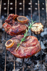 Aromatic veal steak on the grill with coals