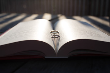 Silver wedding rings on the book