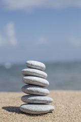 Fototapeta na wymiar stack of pebble stones on balance on sand