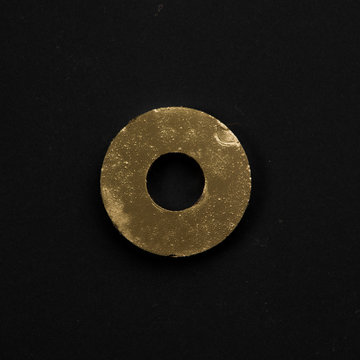Golden puck (gasket) isolated on black background. Symbolic repa