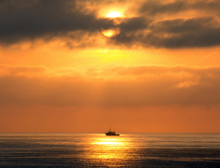 Naklejka na ściany i meble Boot auf der Nordsee bei Sonnenuntergang