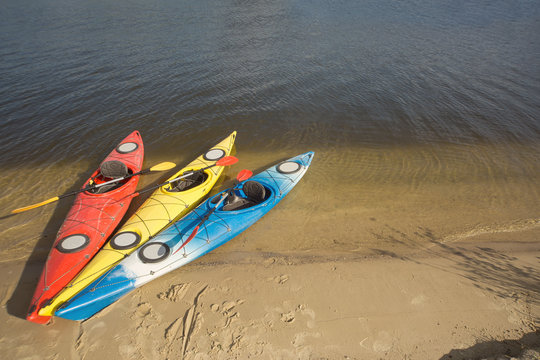 Camping with kayaks on the beach on a sunny day.